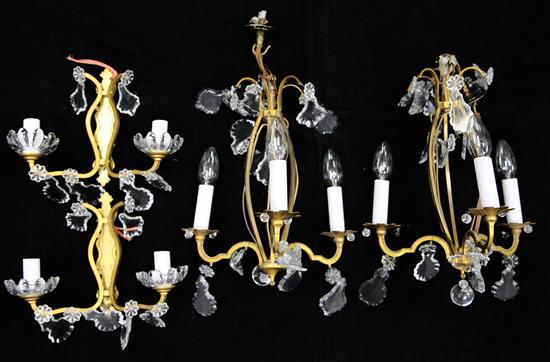 A pair of 1960s Cristalleries de Baccarat gilt metal three branch chandeliers and a pair of similar wall lights.